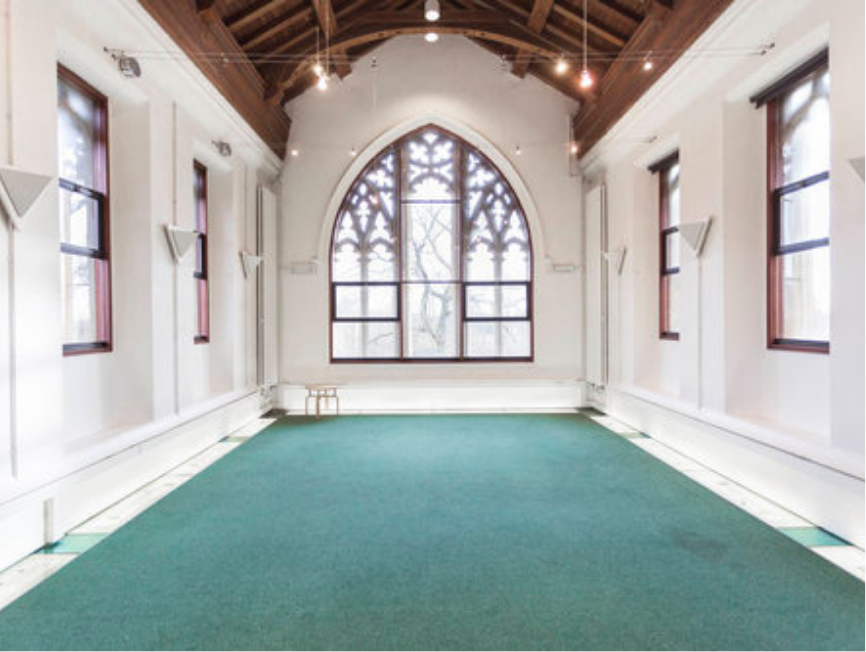 Annex with large arched windows and teal floor