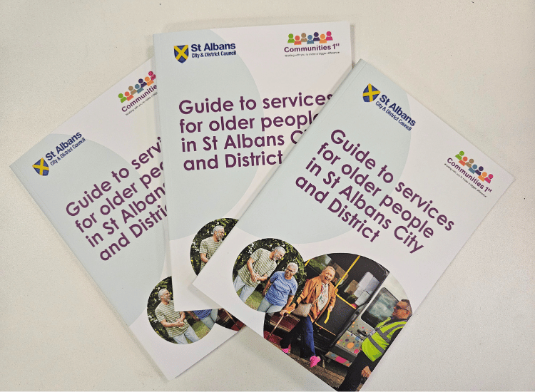 A stack of 'Guide to services for older people in St Albans City and District' leaflets from St Albans Council and Communities 1st.