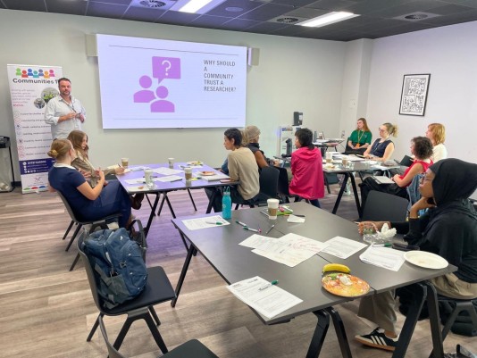a man presenting to a group of people seated in a room