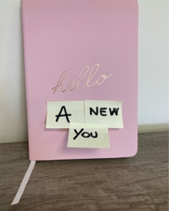 'a new you' text written on a pink book