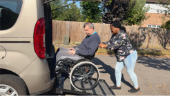 a man in a wheelchair assisted by a woman