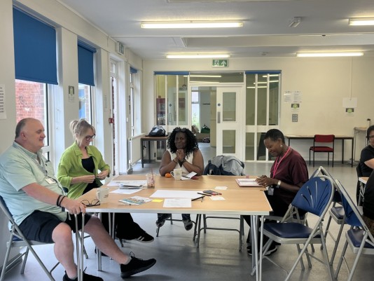 colleagues sitting around a table at communities 1st
