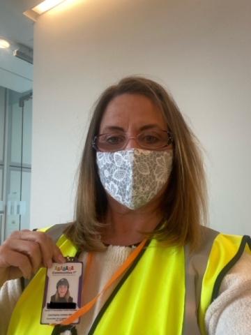 Volunteer holding their ID badge and lanyard