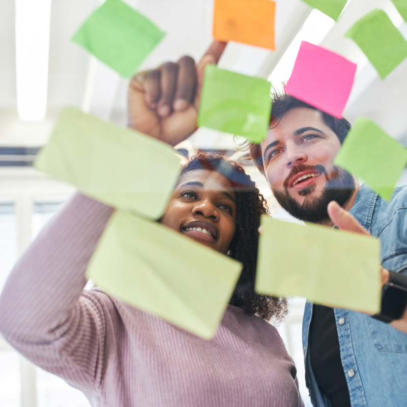 Two people evaluating the contents of post-it notes
