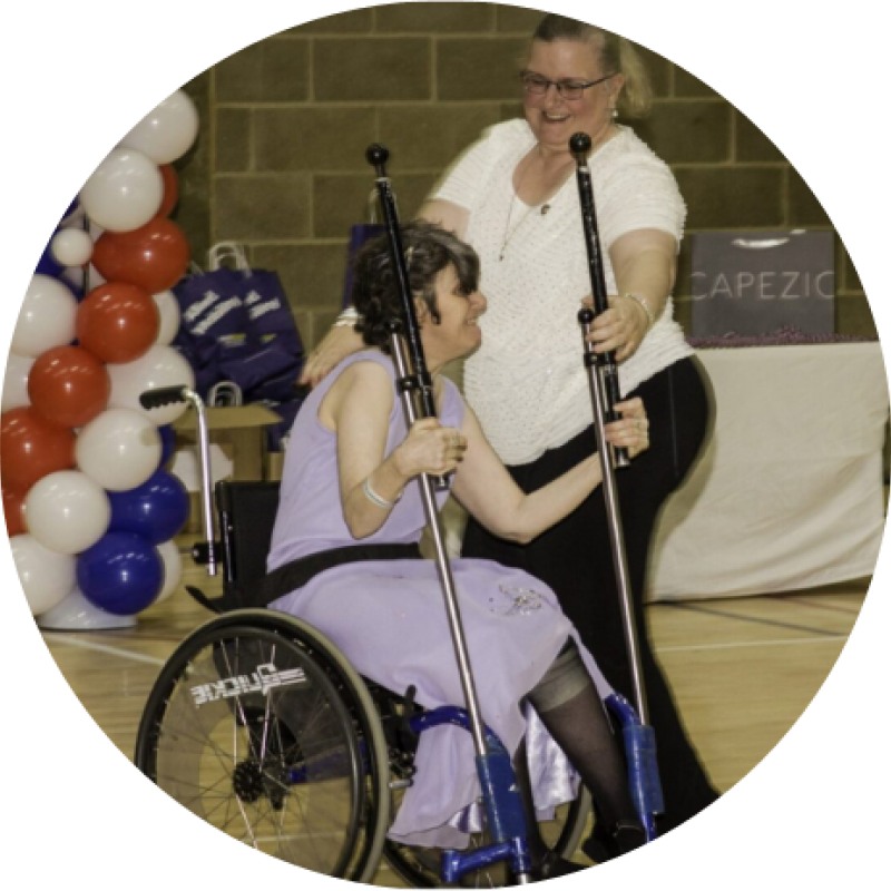 A dance intstructor supportively teaching a wheelchair user