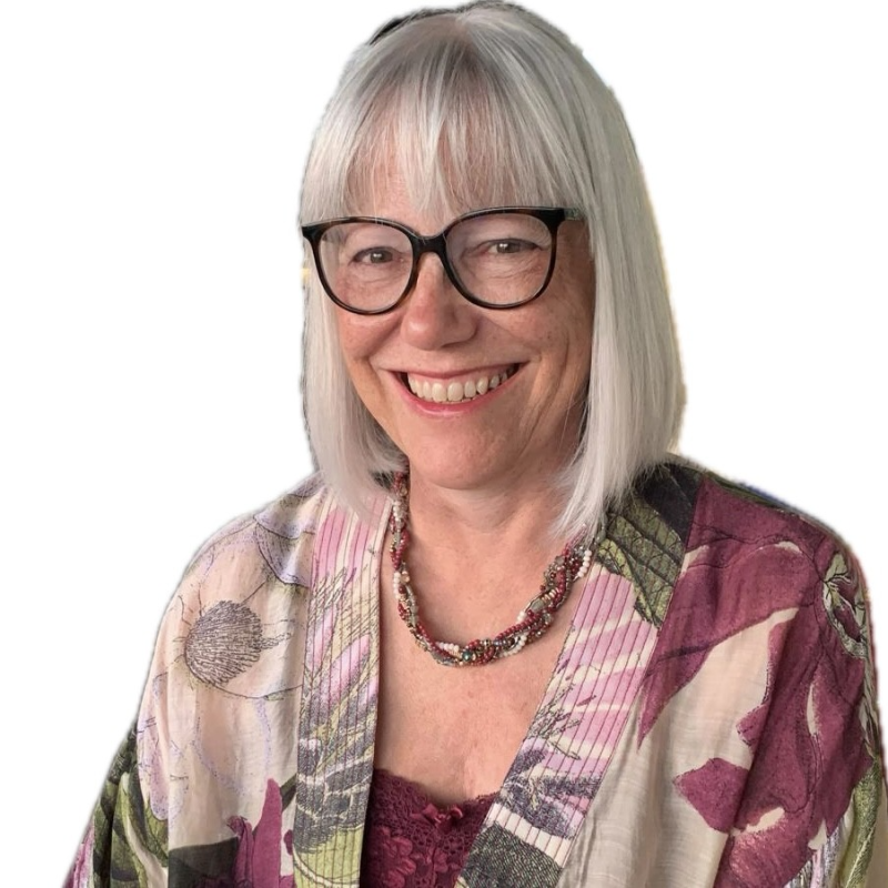 A picture of a lady, she has shoulder length white hair and a floral top. 