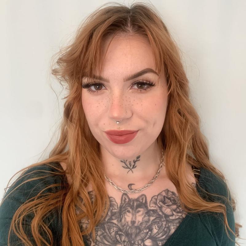 woman with light brown hair wearing a green sweater