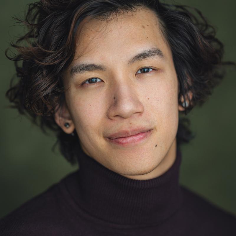 Headshot of a man wearing a black sweater
